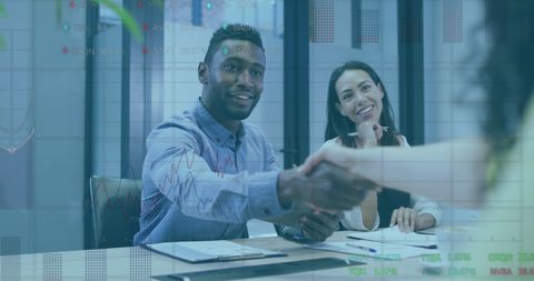 Business Professionals Shaking Hands Over Financial Data Overlay