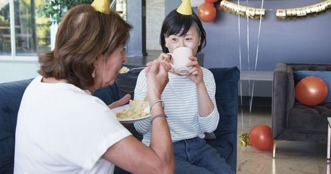 Senior friends celebrating birthday party with cake and tea
