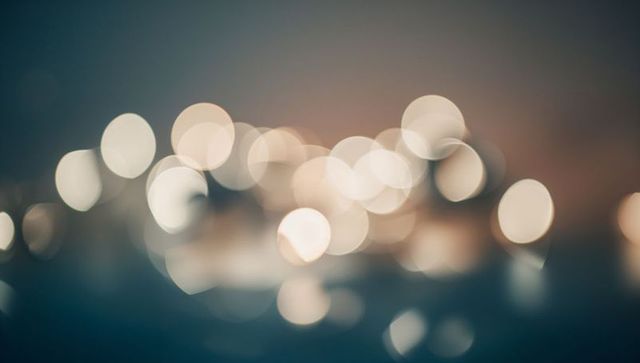 Glowing teal and amber bokeh lights reflecting, creating dreamy defocused background