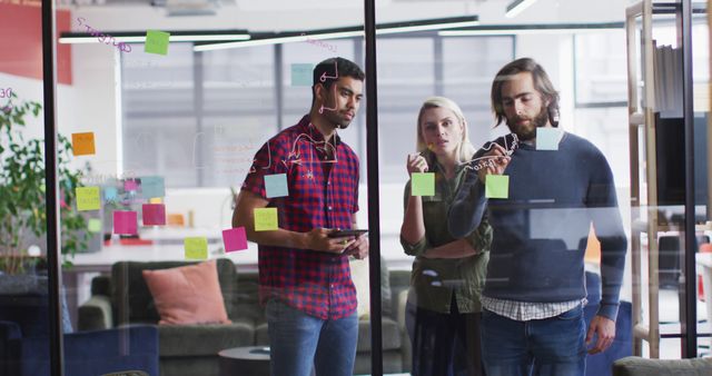 Business Team Brainstorming Ideas on Glass Wall with Sticky Notes in Modern Office - Download Free Stock Images Pikwizard.com