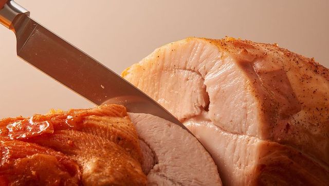 Carving Roasted Turkey Breast with Stainless Steel Knife, Golden Glaze and Juicy Texture