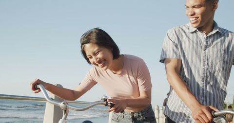 Happy Couple Cycling on Beach Promenade Enjoying Summer Sunset