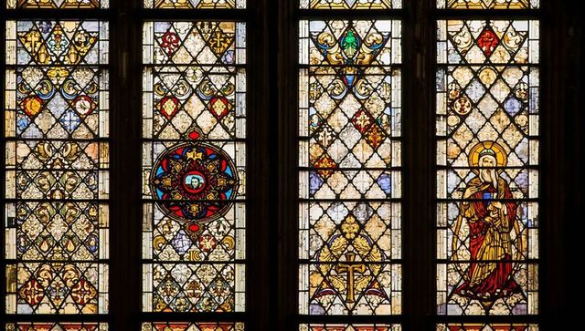 Gothic stained glass windows with saint and medallion decor