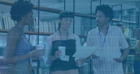 Three team members collaborating over data charts and documents in modern coworking library