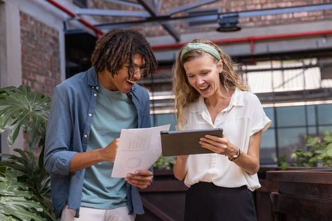 Diverse Coworkers Collaborating with Technology in Loft Office