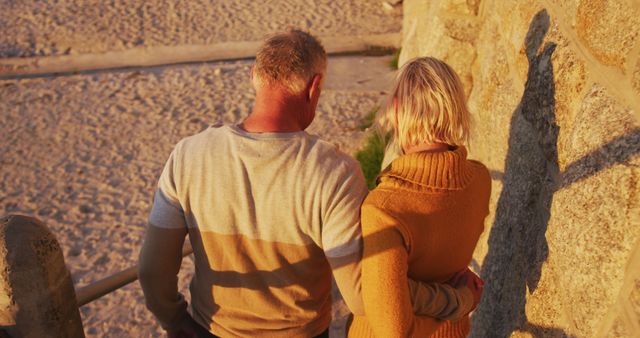 Senior caucasian couple walking down stairs at seaside on sunny day. Summer, senior lifestyle, vacation and activity, unaltered.