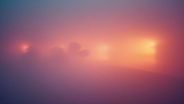 Mystical dawn over misty mountain silhouettes with pastel fog
