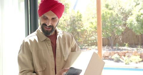 Courier supervising delivery process with smartphone at door