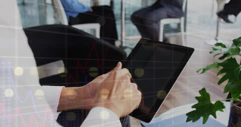 Businessman Uses Digital Tablet for Data Analysis in Office Setting