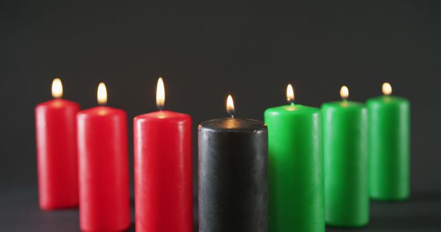 Composition of halloween green, black and red lit candles against black background. halloween tradition and celebration concept digitally generated image.