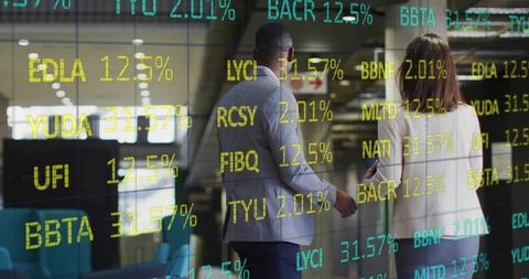 Finance Professionals Walking in Modern Office with Digital Stock Tickers