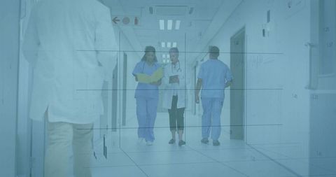 Medical Staff Collaborating in Hospital Corridor with Files and Tablets