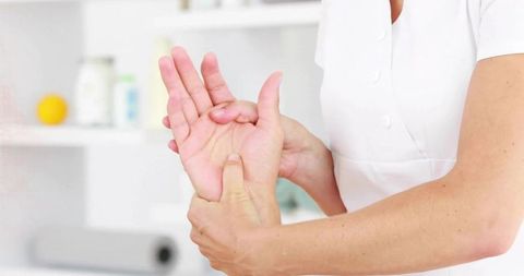 Masseuse offering therapeutic hand massage in relaxing day spa