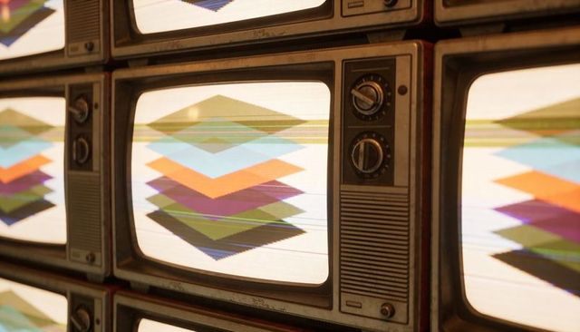 Displaying stacked crt televisions with layered diamond patterns and vintage rotary dials