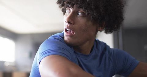 Curly-haired man in motion during fitness routine