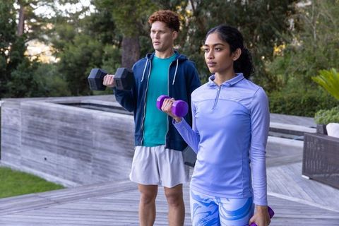 Diverse Workout Partners Lifting Dumbbells Outdoors