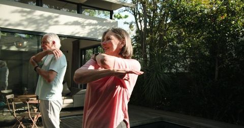 Active Senior Couple Stretching on Patio for Wellness and Relaxation