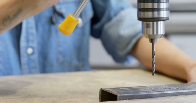 Person using drilling machine on metal surface in workshop - Download Free Stock Images Pikwizard.com