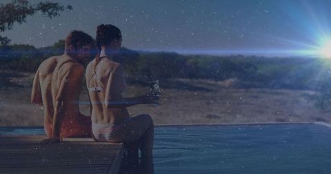 Romantic Couple Relaxing at Scenic Poolside with Sparkling Night Sky
