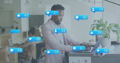 Young professional typing at standing desk with floating social media notifications overlay
