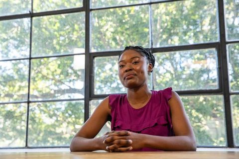 Professional woman sitting by large window in bright workspace