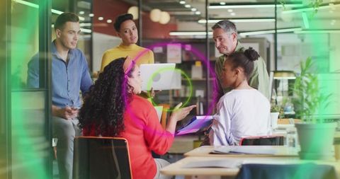 Leading collaborative meeting in modern open-plan office with laptop and documents