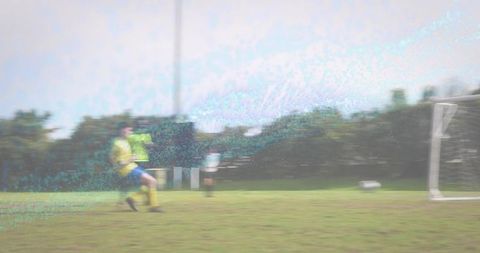 Youth soccer players running toward goal on grass pitch with motion blur and copy space