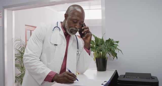 Senior African American Doctor Taking Notes While Talking on Phone - Download Free Stock Images Pikwizard.com