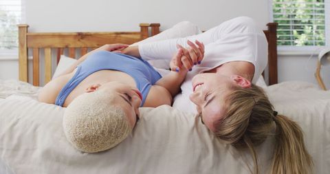 Happy Diverse Female Couple Relaxing in Bedroom