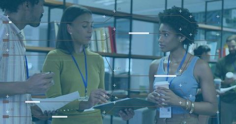 Team collaborating around clipboard and coffee in modern open office workspace