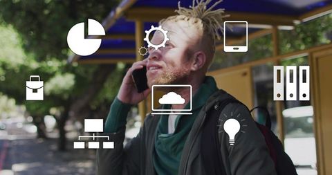 Urban commuter speaking on smartphone at yellow bus shelter with cloud tech icons