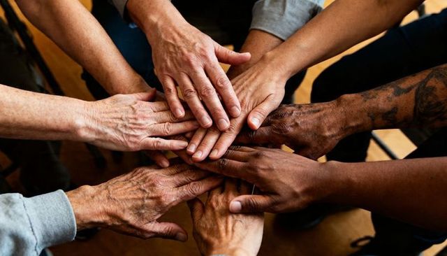 Diverse Hands Stacked in Unity Showing Teamwork Solidarity and Multigenerational Support