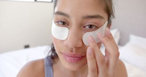 Teen girl applying under eye masks for skin care routine