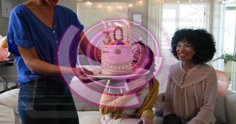 Friends celebrating 30th birthday at home presenting cake with candles and balloons