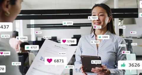 Asian businesswoman presenting quarter report with social media metrics in open-plan office