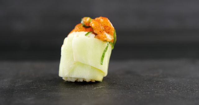 Close-up of gourmet sushi roll with cucumber and topping on black background - Download Free Stock Images Pikwizard.com