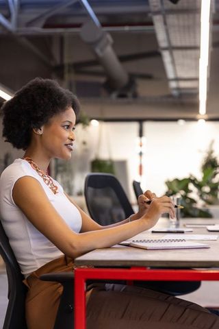 Professional African American Woman Taking Notes in Modern Office