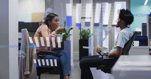 Diverse Team Discussing Data with Digital Graphs Overlay in Modern Office