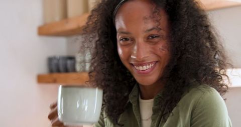 Smiling Woman Enjoying Coffee in Cozy Kitchen Setting