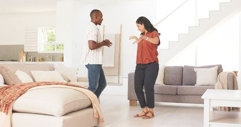 Couple dancing in modern bright living room, casual home joy and contemporary interior