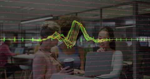 Three women collaborating at coworking table with laptop, coffee and data waveform overlay