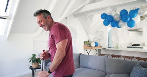 Joyful couple tidying up homespace after celebration gathering