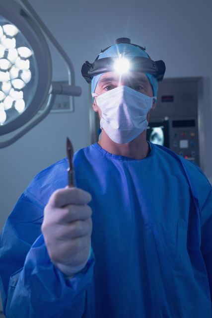 Male surgeon holding a scalpel instrument in operating room at hospital