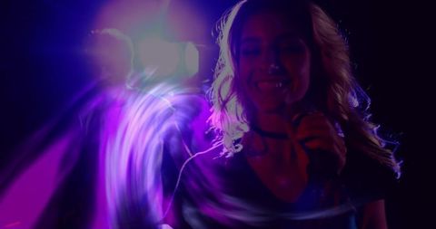 Female singer performing under purple stage lights with motion light trails and lens flare