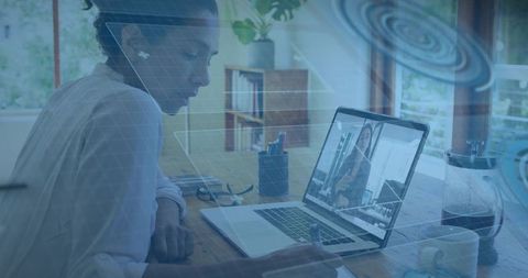 Remote professional taking notes during video conference at home workspace with laptop