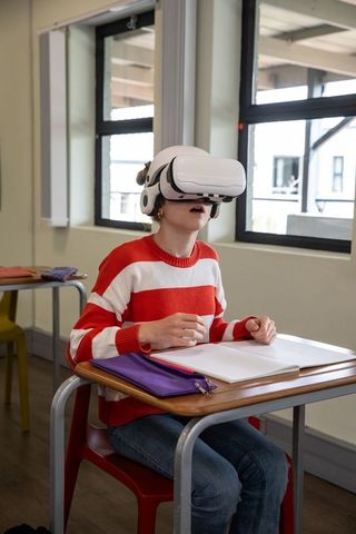 Young Student Learning with VR Headset in Modern Classroom
