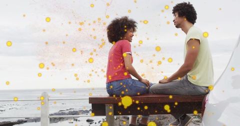 Couple Conversing by Coastal Shore with Enchanting Glow