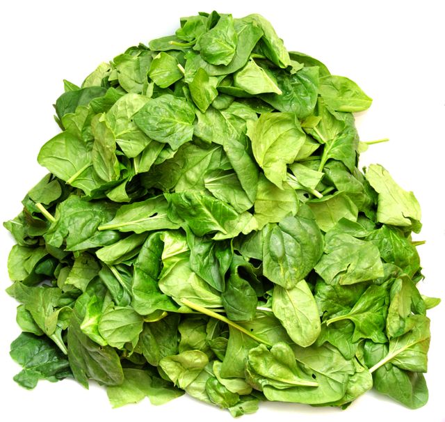 A vibrant and appealing pile of fresh organic spinach leaves, isolated on a white background. Perfect for healthy eating concepts, vegetarian cooking, diet planning, food blogs, and restaurant menus. This image can be used for promotional materials in grocery stores, organic food markets, and nutritional websites.
