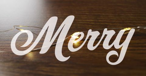 Festive Merry Text with Warm Lights on Wooden Surface