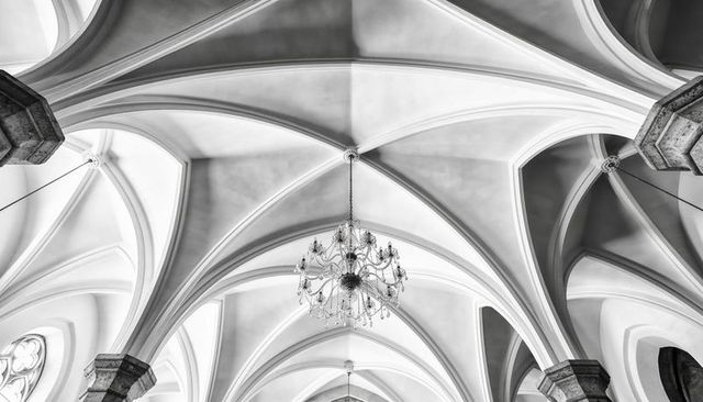 Gothic vaulted ceiling showing ribbed arches, keystone convergence and crystal chandelier